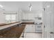 Well-lit kitchen features white cabinets, stainless steel sink, and countertop with seating for a guest at 2248 Ventana Ln, Raleigh, NC 27604
