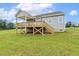 Expansive back deck with a covered area and stairs leading down to the spacious, grassy yard at 261 Kissington Way, Benson, NC 27504