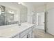 Bright bathroom featuring a large mirror, quartz countertops, and a glass-enclosed shower at 261 Kissington Way, Benson, NC 27504