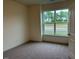 Cozy bedroom featuring a neutral carpet, white walls, and a large window offering outdoor views at 261 Kissington Way, Benson, NC 27504