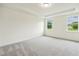Spacious bedroom featuring plush carpeting, tray ceilings, and natural light from two windows at 261 Kissington Way, Benson, NC 27504