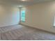Neutral bedroom with carpeted floors, white walls, and a window for natural light at 261 Kissington Way, Benson, NC 27504