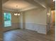 Spacious dining room with decorative trim, updated chandelier, and view to the hallway and the front door at 261 Kissington Way, Benson, NC 27504