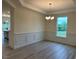 Bright dining room with modern chandelier, white trim, and large window that offers outdoor views at 261 Kissington Way, Benson, NC 27504