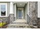 Inviting entryway with stone accents and a neutral-colored front door at 261 Kissington Way, Benson, NC 27504