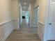 Inviting hallway with white trim, neutral walls, and wood-look floors creates a bright and spacious entry at 261 Kissington Way, Benson, NC 27504