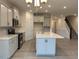 Features an island, stainless steel appliances, modern cabinets, and hardwood floors with access to the staircase at 261 Kissington Way, Benson, NC 27504