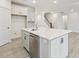 Bright kitchen with stainless steel dishwasher, white cabinets, and island with quartz countertop at 261 Kissington Way, Benson, NC 27504
