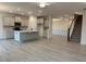 Open-concept kitchen features an island, stainless appliances, and views of a living area and staircase at 261 Kissington Way, Benson, NC 27504