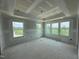 A large bedroom with many windows and a tray ceiling, ready for finishing at 303 Chesapeake Cmns St # 99, Garner, NC 27529