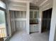 A butler's pantry with cabinets awaits completion, with a doorway to the deck, and a door frame to another room at 303 Chesapeake Cmns St # 99, Garner, NC 27529
