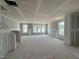 Unfinished living room with stairs shows many large windows providing natural light with a view of the outside at 303 Chesapeake Cmns St # 99, Garner, NC 27529