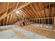 Spacious attic featuring unfinished flooring and exposed beams with insulation at 4701 Regalwood Dr, Raleigh, NC 27613