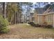 Side view of brick home with manicured bushes next to a tree-lined yard and walking path at 4701 Regalwood Dr, Raleigh, NC 27613