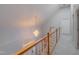 Hallway featuring a grand chandelier, wood railing, and neutral carpet at 4701 Regalwood Dr, Raleigh, NC 27613
