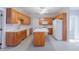 Well-lit kitchen with wood cabinets, white appliances, and an island with counter space at 4701 Regalwood Dr, Raleigh, NC 27613