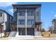 Modern townhome with gray siding, black framed windows, and two-car garage at 1000 Addison Pl # 101, Raleigh, NC 27610