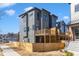Rear exterior view with a wood fence, a private deck and gray siding on a contemporary townhome at 1000 Addison Pl # 101, Raleigh, NC 27610