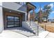 View of a garage, featuring an aluminum and translucent glass door, and gray stone steps at 1000 Addison Pl # 101, Raleigh, NC 27610