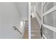 Bright hallway with wood floors, a staircase, and natural light streaming through the windows at 1000 Addison Pl # 101, Raleigh, NC 27610