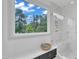 Bathroom featuring white marble shower with bench seating and large window overlooking green trees at 1000 Addison Pl # 102, Raleigh, NC 27610