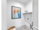 Laundry room features gray tile flooring, white cabinetry, and decorative art and accessories at 1000 Addison Pl # 102, Raleigh, NC 27610