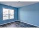 Clean bedroom featuring blue walls, modern flooring and a window providing natural light at 1212 Southgate Dr, Raleigh, NC 27610