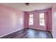 Bright bedroom with pink walls, two windows, and laminate floors at 1212 Southgate Dr, Raleigh, NC 27610
