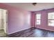 Bedroom features wood-look flooring, large windows, and painted pink walls at 1212 Southgate Dr, Raleigh, NC 27610