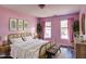 Bright bedroom with pink walls, two windows, and hardwood floors at 1212 Southgate Dr, Raleigh, NC 27610