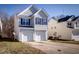 View of the house featuring a two-car garage and a well-maintained lawn at 1212 Southgate Dr, Raleigh, NC 27610