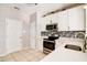 Modern kitchen featuring white cabinetry, stainless steel appliances, and light countertops at 1212 Southgate Dr, Raleigh, NC 27610
