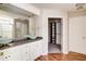 En-suite bathroom featuring double vanity sinks, large mirror, and a walk-in closet at 1212 Southgate Dr, Raleigh, NC 27610