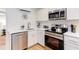 Updated kitchen with stainless steel appliances, white cabinetry and tile backsplash, and breakfast bar at 1309 Hudson Ave # A7, Durham, NC 27705