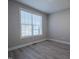 This bedroom features gray walls, gray wood floors, and a large window for natural light at 167 Logbridge Rd, Chapel Hill, NC 27516