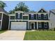 Charming two-story home with a two-car garage, dark siding, and manicured lawn at 219 Augusta Pond Way # 157, Raleigh, NC 27603