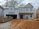 Under-construction two-story home featuring a two-car garage and a covered entry, awaiting its finishing touches at 219 Augusta Pond Way # 157, Raleigh, NC 27603