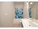 Bright bathroom with colorful blue tile accent wall, tub, shower, white sink and toilet at 600 S Duke St # 26, Durham, NC 27701