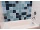 Close-up of a bathtub with blue accent tile and chrome faucet and shower head at 600 S Duke St # 26, Durham, NC 27701