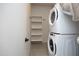 A laundry room with a stacked washer and dryer, shelving, and a tile floor at 600 S Duke St # 26, Durham, NC 27701