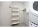 Bright laundry room with stacked washer/dryer, tiled floor, and shelving unit at 600 S Duke St # 26, Durham, NC 27701