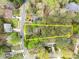 An aerial view showcases a wooded property surrounded by mature trees and landscaping in a neighborhood setting at 102 Pinehill Way, Cary, NC 27513