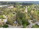 A tranquil aerial view of a wooded neighborhood and a lush green landscape with mature trees and winding roads at 102 Pinehill Way, Cary, NC 27513