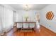 A charming dining room features a wooden table, chandelier, white chairs, and hardwood flooring at 102 Pinehill Way, Cary, NC 27513