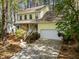 Charming yellow two-story home with a well-manicured lawn and inviting front porch and attached two car garage at 102 Pinehill Way, Cary, NC 27513