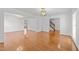Bright and airy living room featuring gleaming hardwood floors, modern light fixtures, and access to a staircase at 102 Pinehill Way, Cary, NC 27513