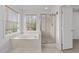 Ensuite bathroom features a separate shower and soaking tub beneath two windows at 102 Pinehill Way, Cary, NC 27513