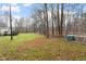 A large, grassy backyard with mature trees and partial fencing offers privacy and outdoor enjoyment at 1705 Old Nc 10 Hwy, Hillsborough, NC 27278