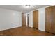 Empty bedroom with hardwood flooring, white walls, and wood paneled closet doors at 1705 Old Nc 10 Hwy, Hillsborough, NC 27278