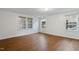 Bright, empty room featuring hardwood floors and multiple windows offering natural light and views of the surroundings at 1705 Old Nc 10 Hwy, Hillsborough, NC 27278